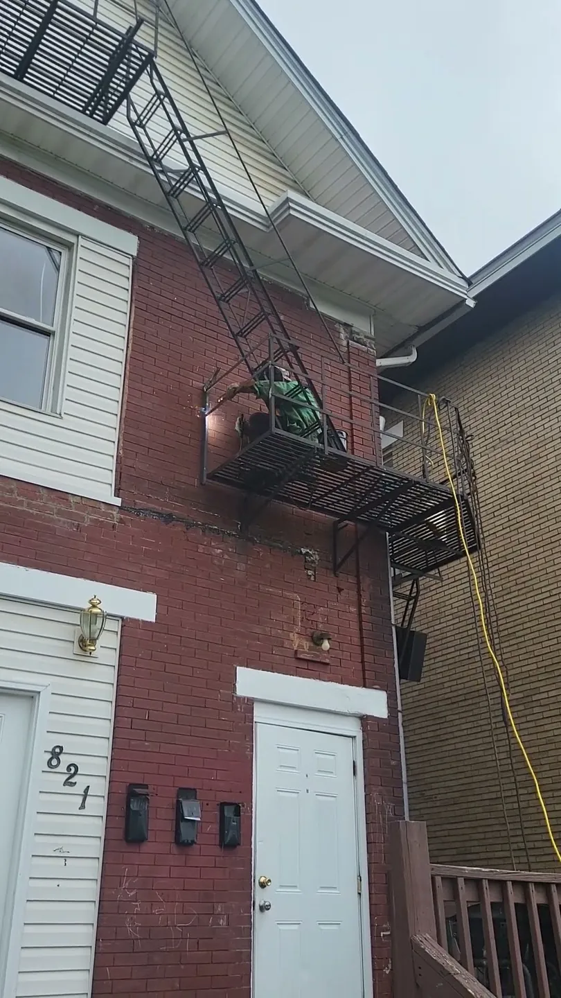 Video preview: welding repairs to an exterior steel fire escape on a brick apartment building