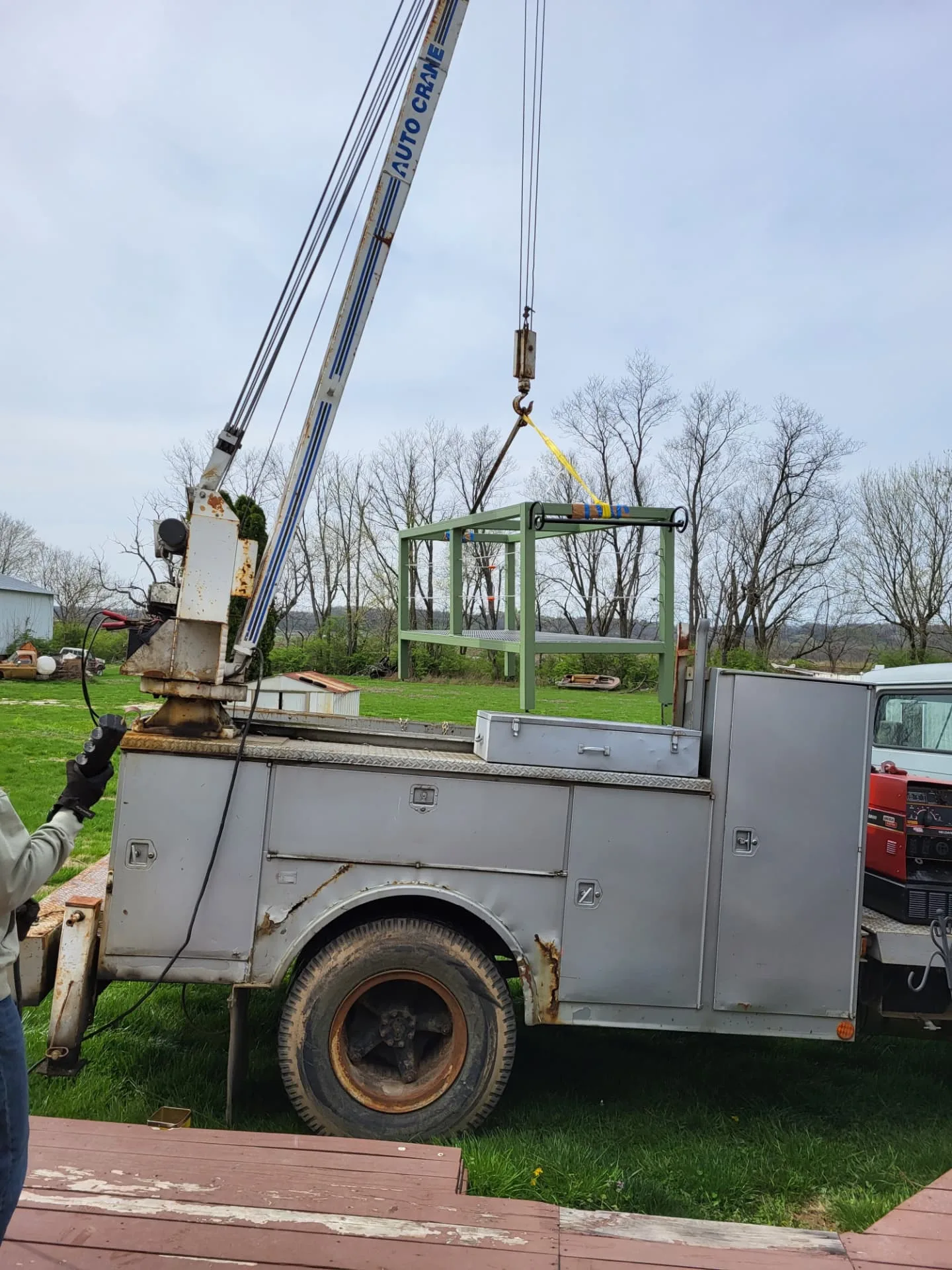 CinStar's Auto Crane boom truck lifting the finished kitchen island base off the truck bed