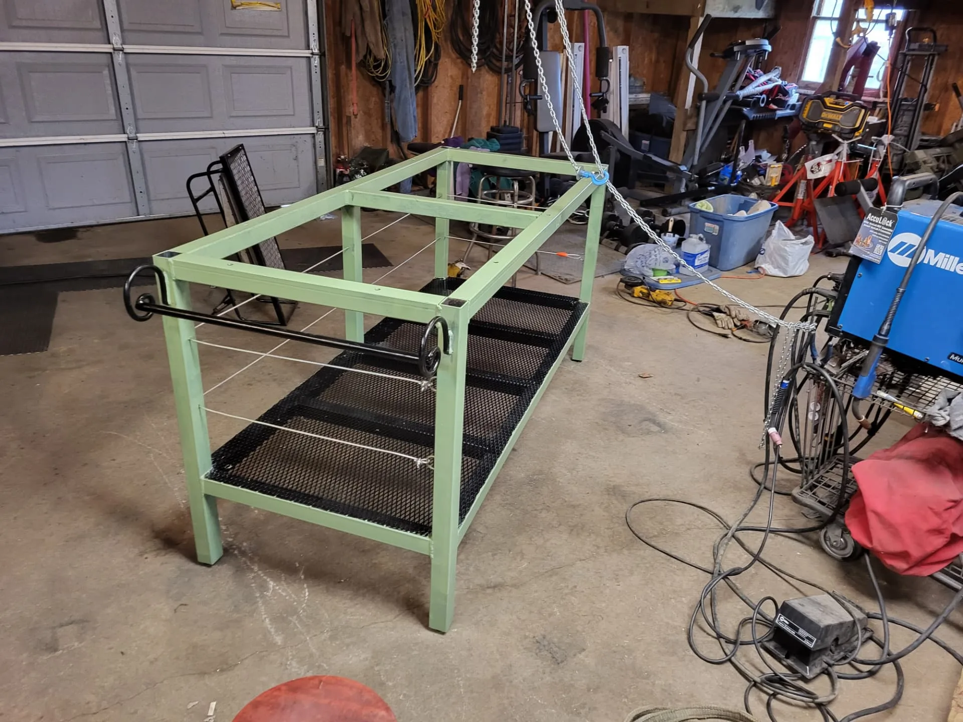 Sage green kitchen island base with forged scroll accents on the end rails, built by CinStar